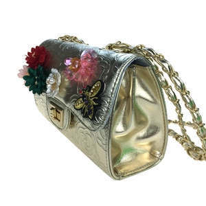 Detail of gold embossed 3D flower evening bag with embroidered bee charm and chain