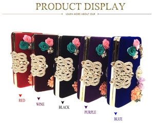 Detailed row of velvet evening clutch bags with 3D satin flowers and crystal buckle
