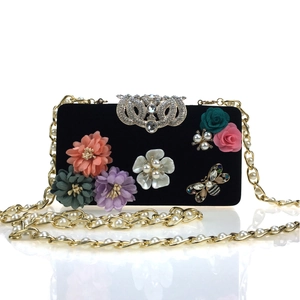 Black velvet clutch bag with 3D silk flowers, bee ornaments, and pearl chain strap