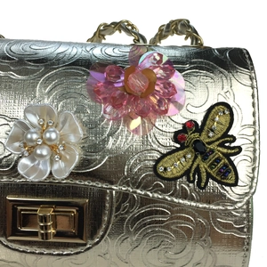 Champagne gold chain bag featuring 3D floral textures and crystal bee embellishments