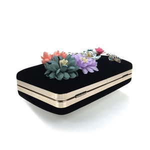 Detail of black velvet evening clutch with 3D fabric flowers, pearls and crystals