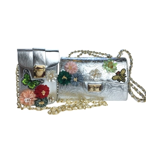 Detail of silver satin floral evening bags with intricate beadwork and pearl chain
