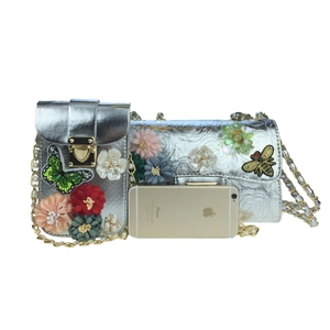 Detail of silver evening bags with 3D satin flowers, sequins and chain straps