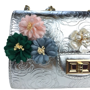 Detail of silver embossed evening bag with handmade satin flowers and pearl beads