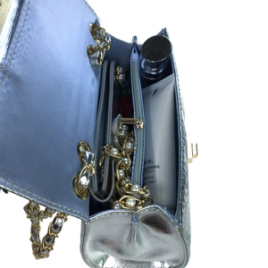 Silver metallic quilted chain bag with blue interior storage for everyday essentials
