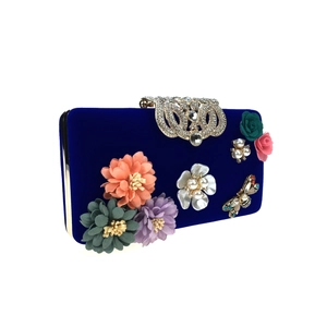 Detailed view of luxury velvet evening bag with 3D floral petals, pearls, and rhinestones