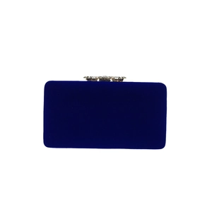 Detailed view of dark blue velvet evening bag with sparkling rhinestone metal clasp closure