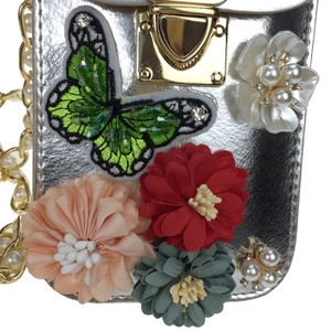 Detail of silver metallic purse with 3D fabric flowers, sequin butterfly and pearl chain