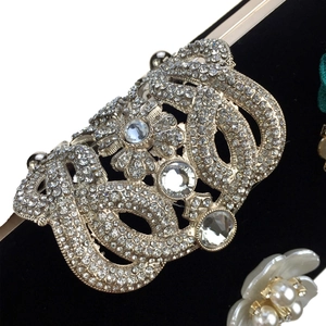 Close-up of luxury velvet clutch with silver crystal rhinestones and large gemstones