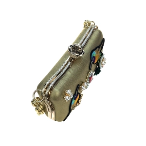 Detailed embroidery of birds and flowers on gold evening clutch with jewel clasp