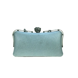 Close-up of evening clutch bag with glitter texture and large rhinestone spherical clasp