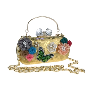 Détail d'une pochette de soirée florale avec fermoir cristal et chaîne perle