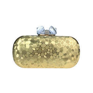 Détail du sac de soirée doré à texture girafe et fermoir en cristal en forme de nœud