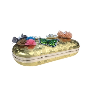 Détails des fleurs en satin 3D, du papillon à paillettes et des perles sur l'embrayage doré