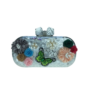 Détail de la pochette de soirée argentée avec fleurs 3D, broderie papillon et perles nacrées