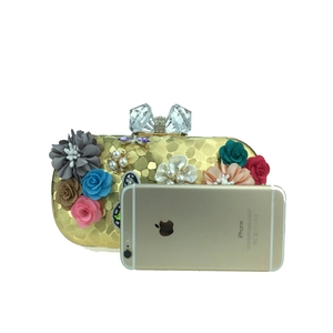Détail d'une pochette de soirée florale avec paillettes, perles et fermoir nœud en cristal