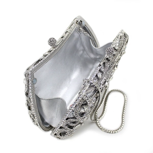 Vue macro d'un sac de soirée argenté à strass avec motifs baroques ajourés et chaînette