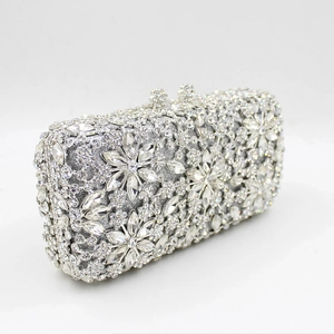 Macro view of crystal flower clasp and shimmering rhinestones on silver evening clutch