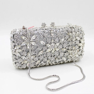 Macro detail of silver rhinestone evening bag featuring floral crystal patterns and snake chain