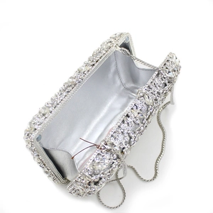 Detailed interior view of silver rhinestone evening clutch with chain strap and satin lining