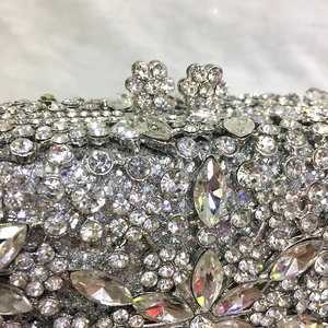 Close-up of luxury silver evening clutch with intricate floral rhinestone and crystal details
