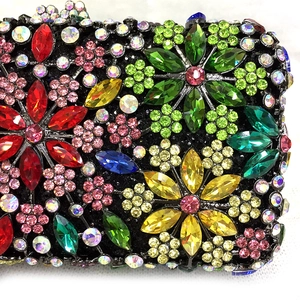 Macro detail of multicolored crystal floral patterns on a luxury metal evening clutch bag
