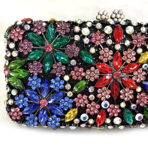 Close-up of luxury evening clutch with colorful floral rhinestones and crystal clasp