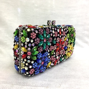 Close-up of vibrant floral rhinestone patterns on a black metal frame evening clutch bag