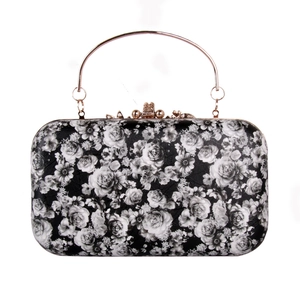 Close-up of vintage rose floral pattern and gold metal handle on evening clutch bag