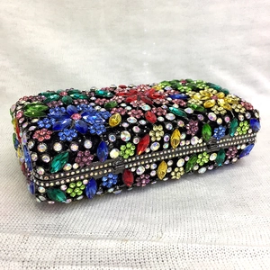 Macro shot of rectangular metal clutch bag with colorful rhinestones and floral crystal pattern