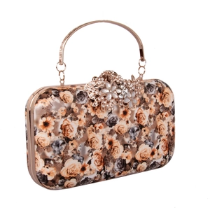 Detailed view of the elegant rose print clutch with a golden metal ring handle and crystal clasp