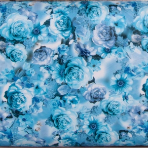 Detail of high-density blue rose floral print pattern on a high-quality evening handbag