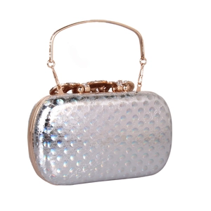 Macro view of silver holographic evening clutch with rhinestone lock and metal handle