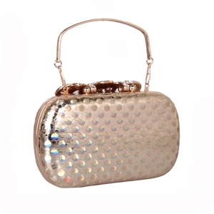 Macro detail of holographic gold clutch with sparkling floral diamond-studded clasp