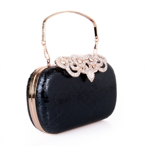 Detail of black snake pattern evening clutch with rose gold ring handle and floral crystal clasp