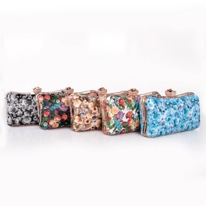 Detail of evening clutch bags with rose gold floral clasps and varied flower patterns