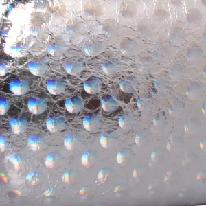 Macro detail of silver holographic laser dot material on evening clutch evening bag