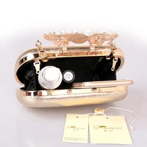 Golden evening clutch bag with bow clasp and rhinestones showing interior capacity
