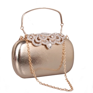 Detail of luxury gold hard-shell evening clutch with sparkling rhinestone scroll pattern