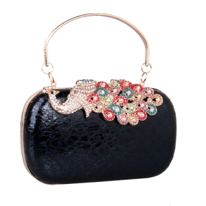 Detail of colorful crystal peacock ornament on black textured luxury evening clutch bag