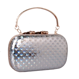 Close-up of holographic texture on a silver evening clutch bag with rose gold metal handle