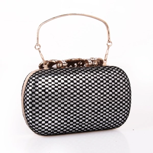 Detail of silver-black checkerboard clutch bag with gold ring handle and rhinestone clasp