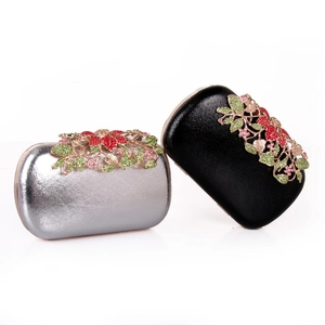 Detail of hard shell evening clutch with metallic leather and rhinestone flower cluster