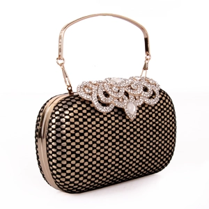 Detail of luxury evening clutch with golden honeycomb pattern and crystal ornament