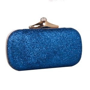 Close-up of sparkling blue sequin clutch with a gold crystal ball clasp and hard shell
