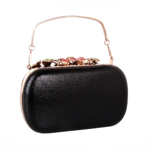 Detail of black hard-case clutch with crystal flower clasp and rose gold handle