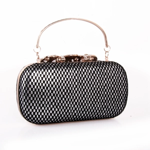 Détail de la pochette de soirée avec poignée or rose et fermoir floral diamanté