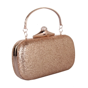 Detail of rose gold sequin clutch bag with crystal spherical clasp and metal handle