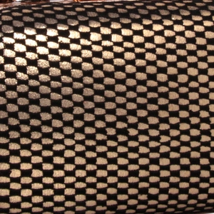 Vue macro détaillée de la texture maille dentelle noir et or sur une pochette de soirée