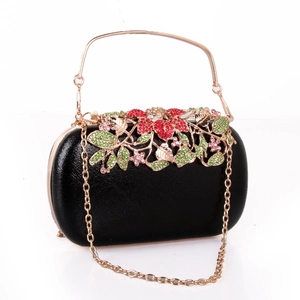 Detail of black PU evening clutch with golden floral metalwork and colorful rhinestones